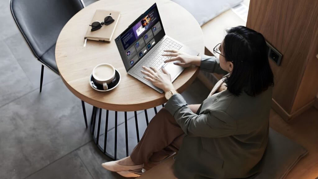 Profesional usando laptop con IA en espacio de trabajo flexible