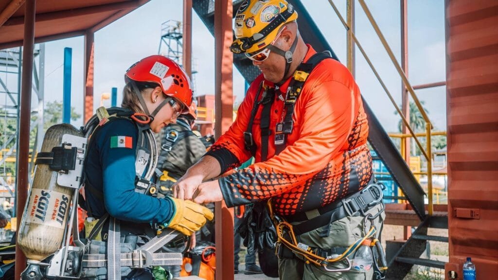 Instructora ajustando equipo de protección a mujer bombero en Spanish Fire School Cartagena 2026