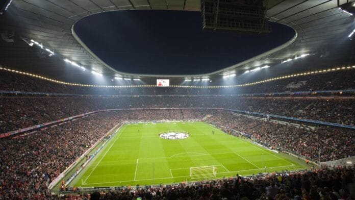 Vista interior de estadio de fútbol con pantallas de seguridad, contexto Mundial 2026 y tecnología smart home