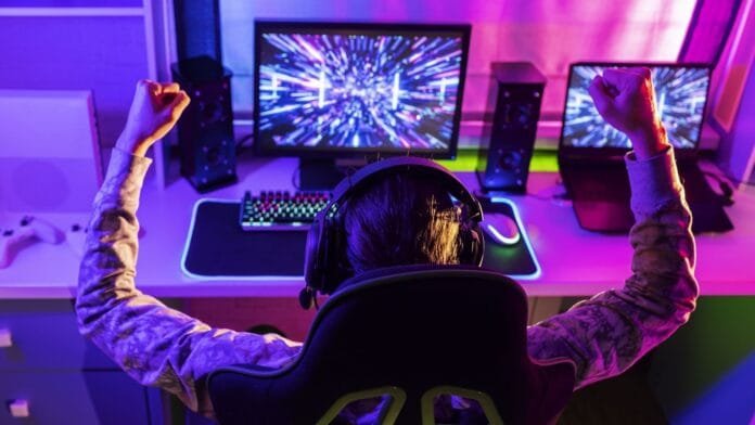 crecimiento-industria-gaming-latinoamerica-2026 Gamer celebrando frente a su setup gaming, representando el crecimiento de la industria del videojuego en Latinoamérica en 2026