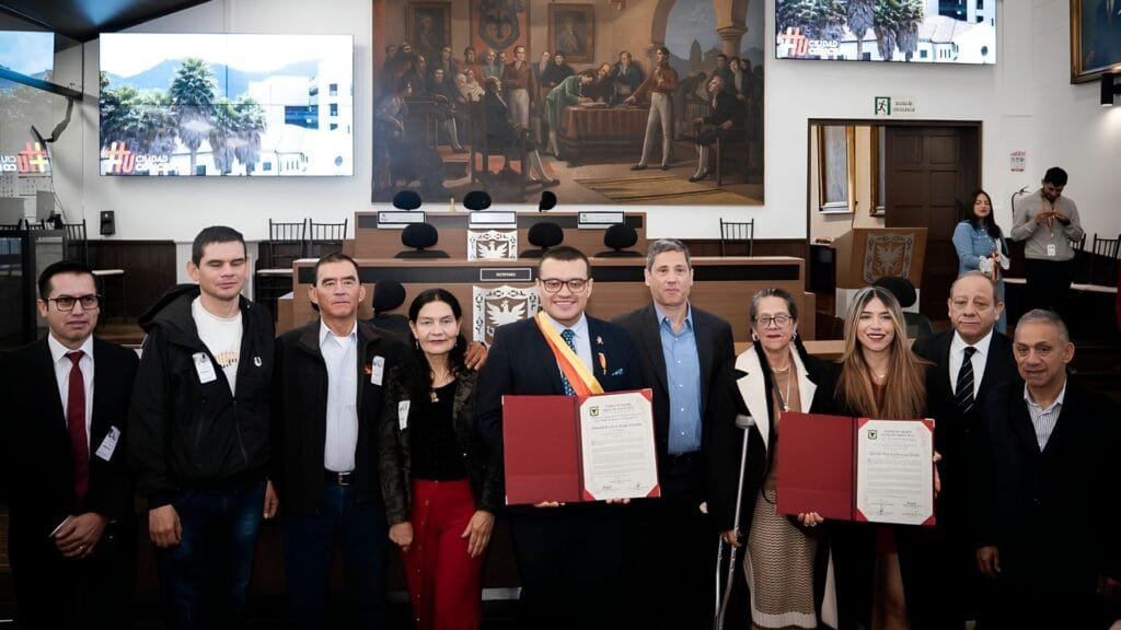 El Concejo de Bogotá condecora a Jhonatan Rojas Ahumada por rescatar la memoria de Bogotá: 12 años de trabajo en medios comunitarios 1 Asistentes a la ceremonia de condecoración en el Recinto Los Comuneros del Concejo de Bogotá, con el mural histórico de fondo